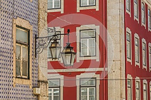 The old, metal, street lamps mounted on colorful tiled buildings in Lisbon, Portugal