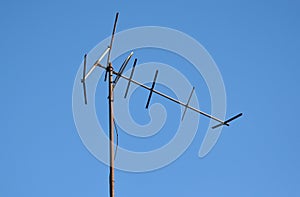Old metal TV antenna against blue sky