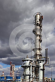 Old methanol distillation rectification refinery column towers and reactors under stormy sky with dark clouds background photo
