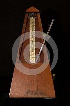 Old metronome with black background