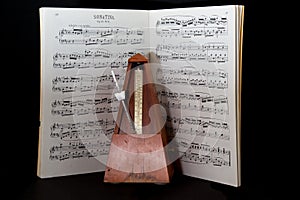 Old metronome with sheet music