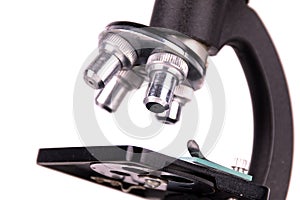 an old microscope stands isolated on a white background on a white surface