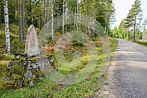 Old mile stone from 1781 near road in Sweden
