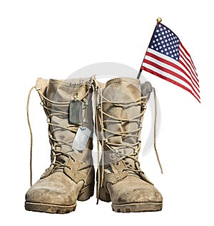 Old military combat boots with the American flag and dog tags