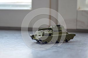 old military toy model of tank stands on the windowsill