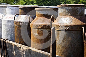 Old milk churns on a cart photo