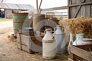 Old milk jugs, cans and bottles at dairy farm photo