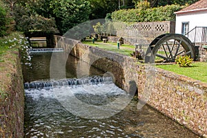 Old mill with a stream enclosed in a stone channel with brickwork