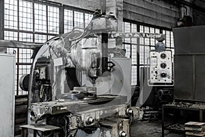 Old milling machine with control panel equipment and tools for metal processing in the workshop of an industrial plant