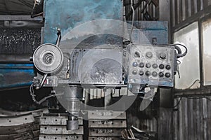 Old milling machine tool with control panel and buttons and equipment for metalworking in the workshop of an industrial plant
