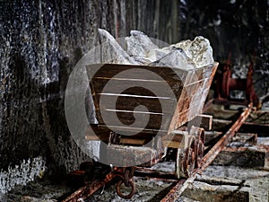 Old mine wagon with illuminated salt stones in Turda salt mine,