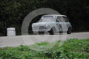 Old Mini Cooper car racing on the road.