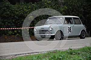 Old Mini Cooper car racing on the road.