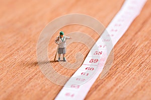 Old miniature traveler with 60th number of age on measuring tape