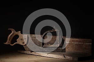 Old Miter box and backsaw close up with selective lighting