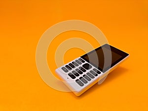 old mobile phone against a bright orange backdrop