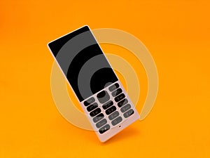 old mobile phone against a bright orange backdrop