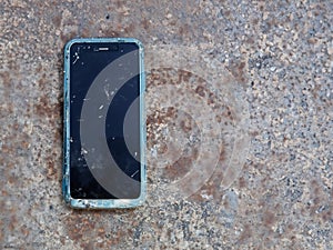 old mobile phone with broken screen on the concrete floor