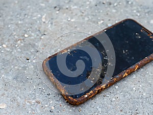 old mobile phone with broken screen on the concrete floor
