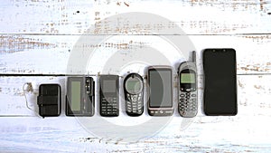 Old mobile phones and pagers isolated on white wooden background