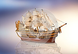 Old model of galleon in abstract background