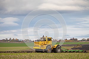 old model tractor working in the field