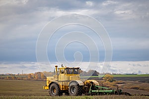 old model tractor working in the field.