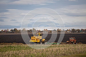 old model tractor working in the field.