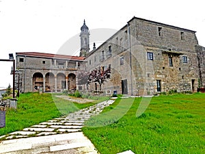 Old monastery a stone path and green grass on a cloudy day. Cistercian monastery of Santa Maria de Xunqueira de Espadanedo photo