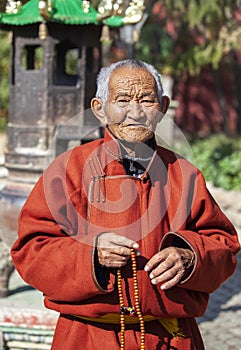 Old mongolian nomad man at a temple