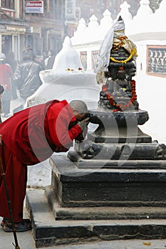 Old monk praying at a statue in Boudnath