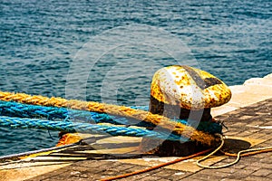 Old mooring bollard with heavy ropes in the port of Gibraltar. Mooring end of a rope anchoring a ship