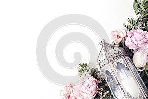 Old Moroccan, Arabic lantern, pink roses, peony flowers and green branches isolated on white table background. Greeting