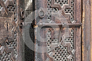 Old Moroccan, wooden door detail. Koranic school, Madrasa Bou Inania, Fes, Morocco photo