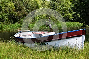 Old motor boat on the river in summer.