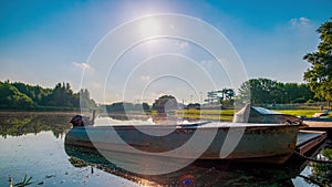 Old motorboat is moored early in the morning. River and sun