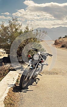 Old motorcycle parked on the road toned