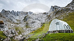 Old mountain hut on a cloudy day with the mountains in the background. Picos de Europa. photo