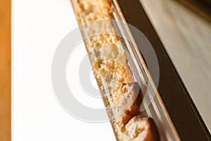 Old mounting foam on the frame of a dismantled plastic window photo