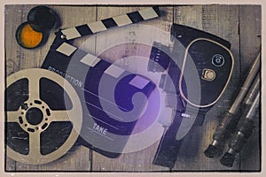 Old movie camera, clapperboard and film on a reel