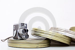 Old movie camera and film canisters on white