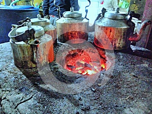 Old mud chulha with tea kettle and fire.