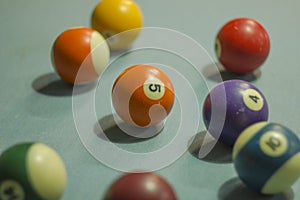 A old multi-colored billiard balls with numbers on blue cloth