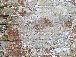 Background of old vintage dirty brick wall with peeling plaster, texture. Old multi colored brick wall