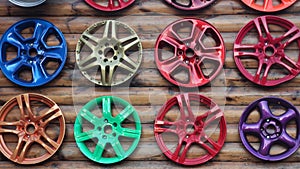 Old multi-colored car rims nailed to a log board for viewing