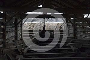 An old multi-ocean boat in storage in a hangar on a lake shore