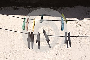 Old multicolored clothespins hanging on clothesline for underwear