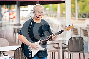 Old musician on the stage performing with an electric guitar
