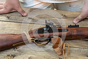 Old muzzle-loading weapon, trigger traditional musket on a wooden table