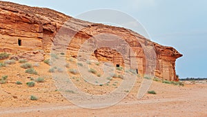 Old Nabatean architecture carved on orange sandstone wall at Jabal Al Ahmar, Hegra in Saudi Arabia, 18 ancient tombs are